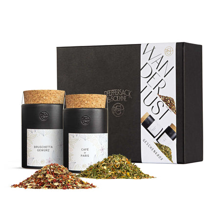 Geschenkbox „Wanderlust“ von Pfeffersack & Soehne mit Bruschetta Gewürz und Café de Paris in schwarzen Keramikdosen, dekorativ arrangiert.